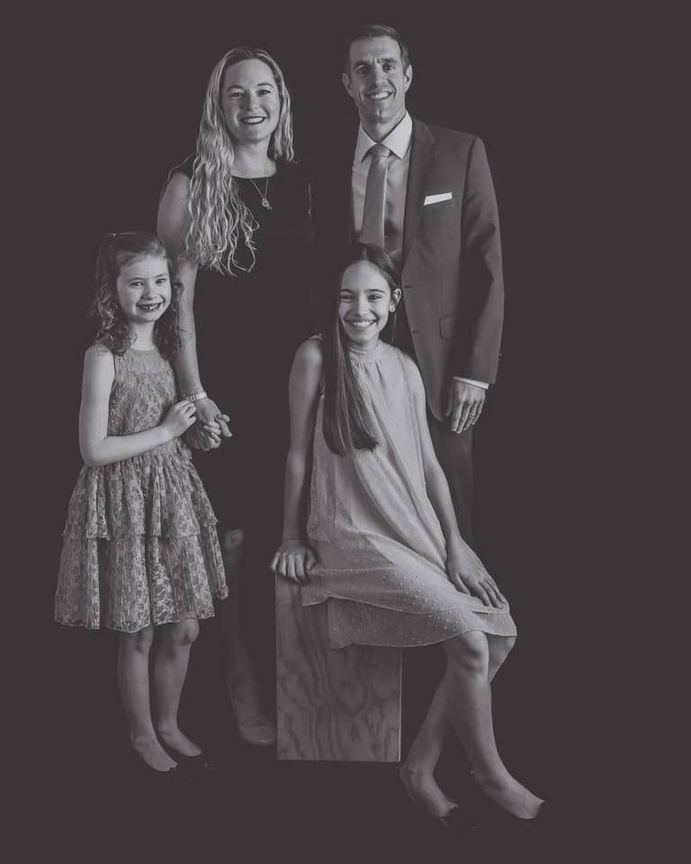 Classic black and white family portrait set in grey tones on a black background in the studio at Studio Kate Portrait Design in Noblesville, IN.